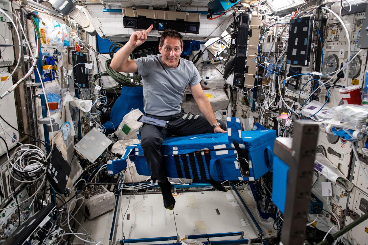 iss065e006534 (April 26, 2021) --- Expedition 65 Flight Engineer Thomas Pesquet of the European Space Agency is pictured inside the Columbus laboratory module setting up hardware for the Grip experiment. The motion study is composed of a series of dexterous manipulation tasks that may lead to improved spacecraft interfaces and deeper insights into human cognition in space.