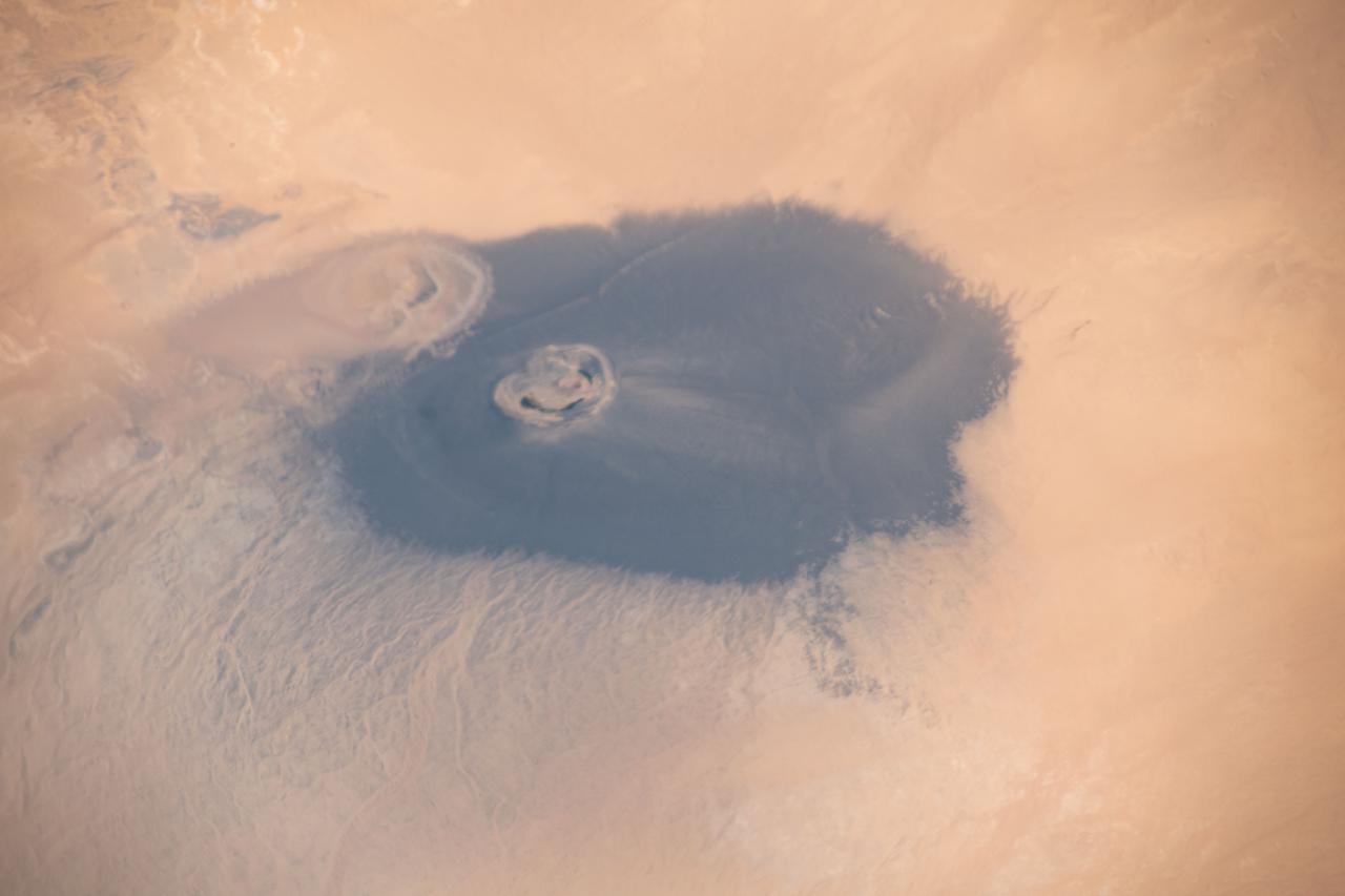 iss065e009516 (April 29, 2021) --- The isolated volcanic crater Waw an Namus in Libya with three small saltwater lakes is pictured from the International Space Station as it orbited 263 miles above the Sahara Desert.