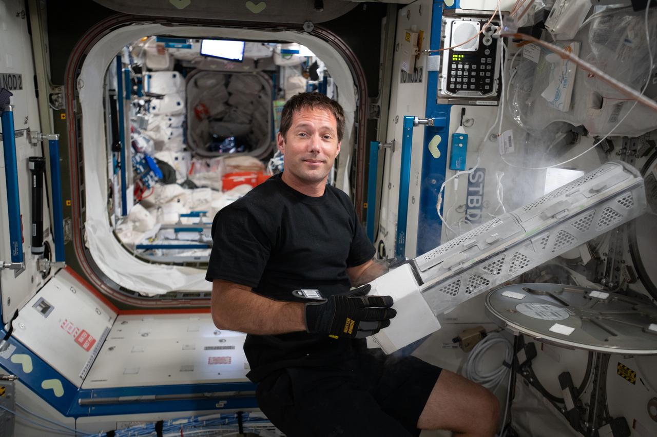 iss065e017719 (May 4, 2021) --- Astronaut and Expedition 65 Flight Engineer Thomas Pesquet of the European Space Agency transfers science samples to a science freezer for the Myotones investigation that observes how microgravity affects the biochemical properties of muscles, such as muscle tone, stiffness and elasticity.