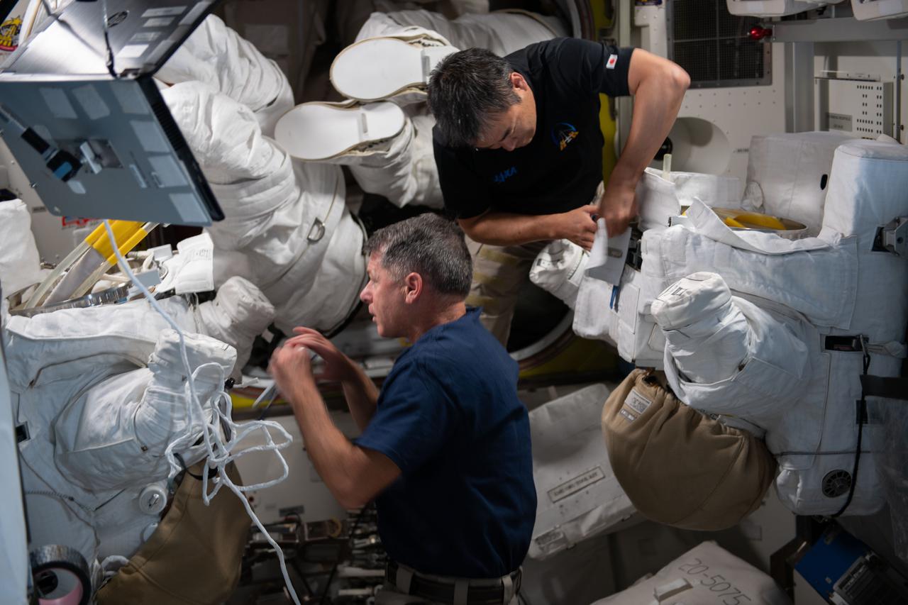 iss065e018983 (May 4, 2021) --- Expedition 65 astronauts Shane Kimbrough of NASA and Akihiko Hoshide of the Japan Aerospace Exploration Agency perform maintenance on a pair of U.S. spacesuits inside the Quest airlock of the International Space Station.