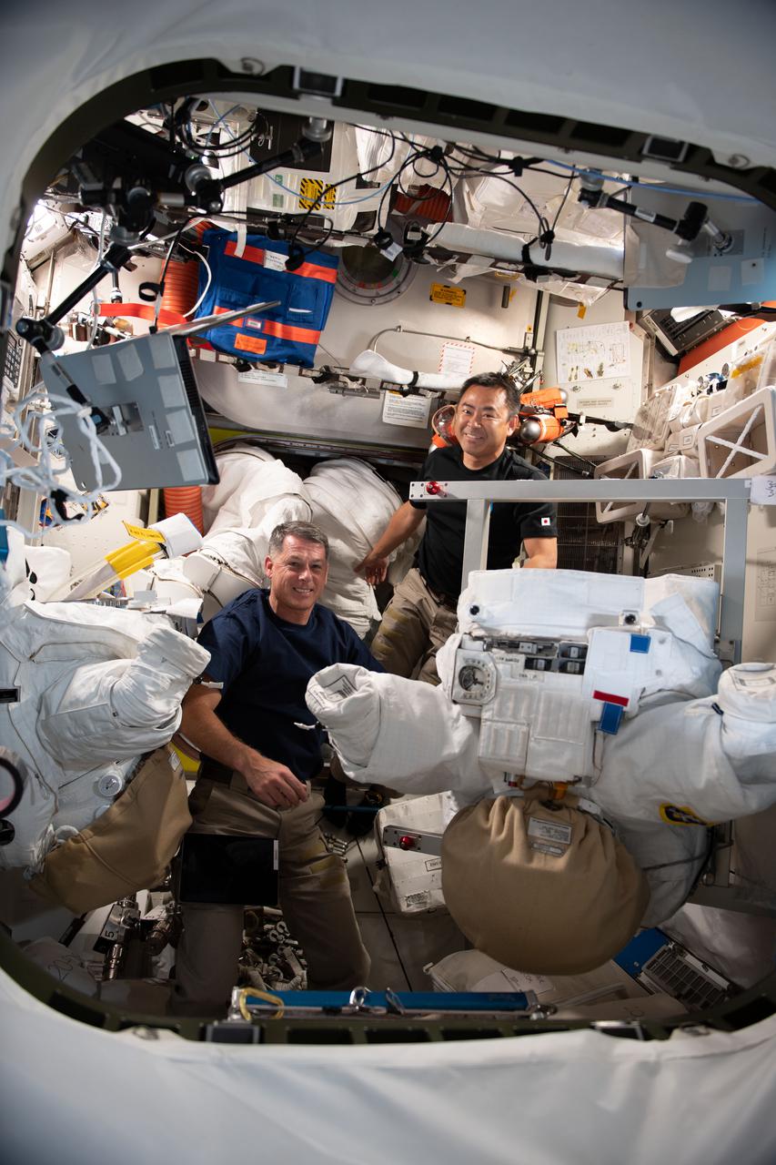 iss065e018991 (May 22, 2021) --- Expedition 65 astronauts Shane Kimbrough of NASA and Akihiko Hoshide of the Japan Aerospace Exploration Agency perform maintenance on a pair of U.S. spacesuits inside the Quest airlock of the International Space Station.