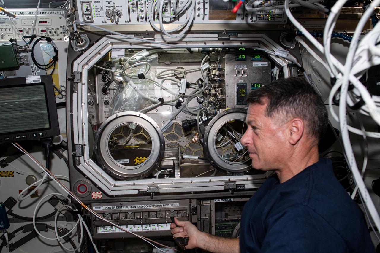 iss065e020580 (May 5, 2021) --- NASA astronaut and Expedition 65 Flight Engineer Shane Kimbrough is pictured in front of the Microgravity Science Glovebox setting up hardware for a physics investigation. The experiment known as Solidification Using a Baffle in Sealed Ampoules, or SUBSA, explores experimental methods of crystallizing melts in microgravity and is expected to result in reduced fluid motion in the melt, leading to better distribution of subcomponents and the potential for improved technology used in producing semiconductor crystals.