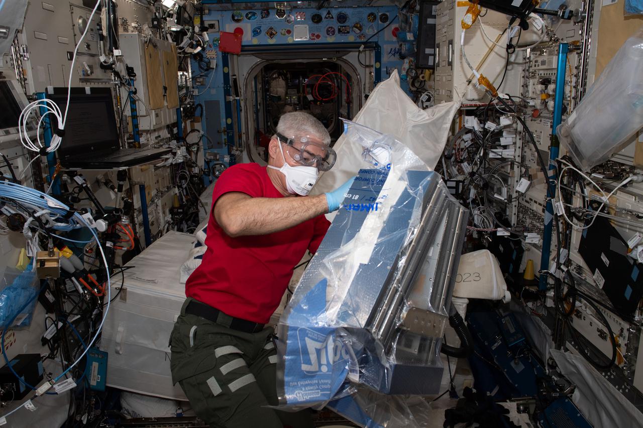 iss065e045718 (May 14, 2021) --- NASA astronaut and Expedition 65 Flight Engineer Mark Vande Hei unpacks research hardware inside the Kibo laboratory module from the Japan Aerospace Exploration Agency.