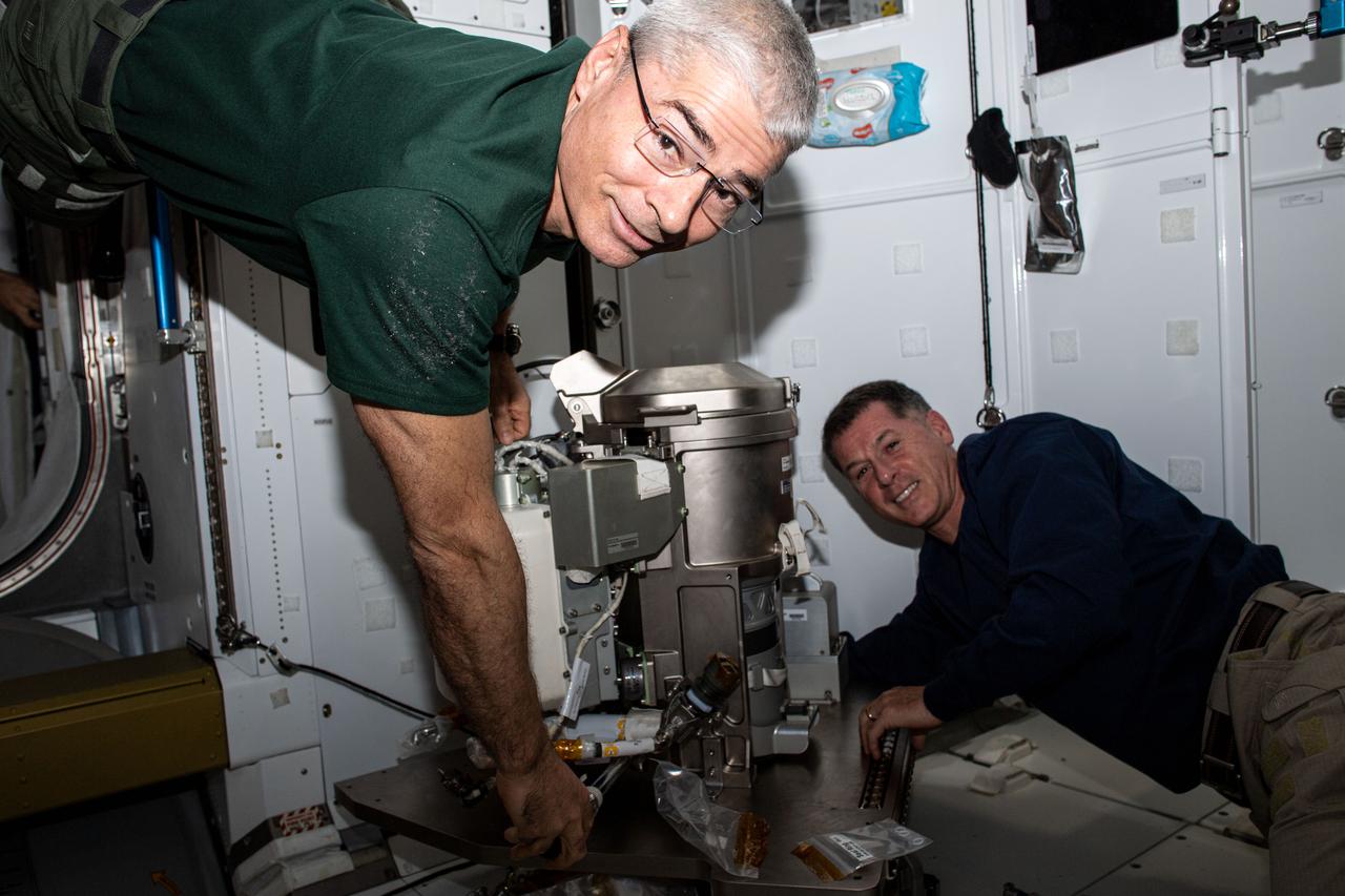 iss065e061144 (May 24, 2021) --- Expedition 65 Flight Engineers Mark Vande Hei (from left) and Shane Kimbrough partner together for orbital plumbing tasks as they install a new toilet inside the International Space Station's Tranquility module.