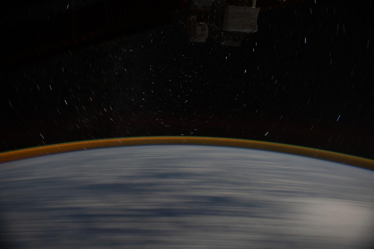 iss065e081769 (May 20, 2021) --- This long exposure photograph, taken from the International Space Station as it orbited 267 miles above the Indian Ocean, reveals Earth's atmospheric glow and star trails.
