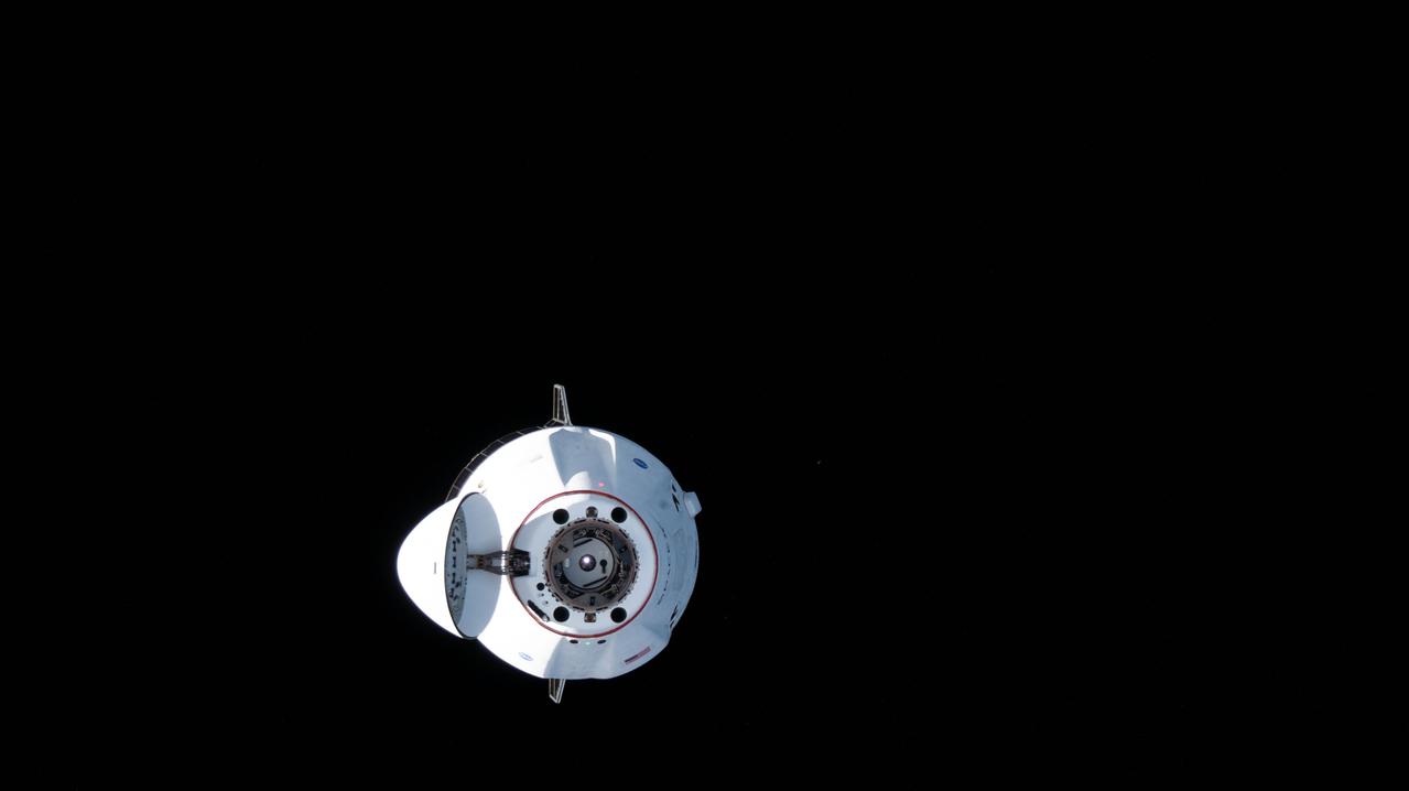 iss065e086721 (June 5, 2021) --- The SpaceX Cargo Dragon resupply ship is pictured approaching the International Space Station carrying over 7,300 pounds of new science, supplies and solar arrays to replenish the Expedition 65 crew. The Cargo Dragon's nose cone is open revealing its hatch and forward docking cone.