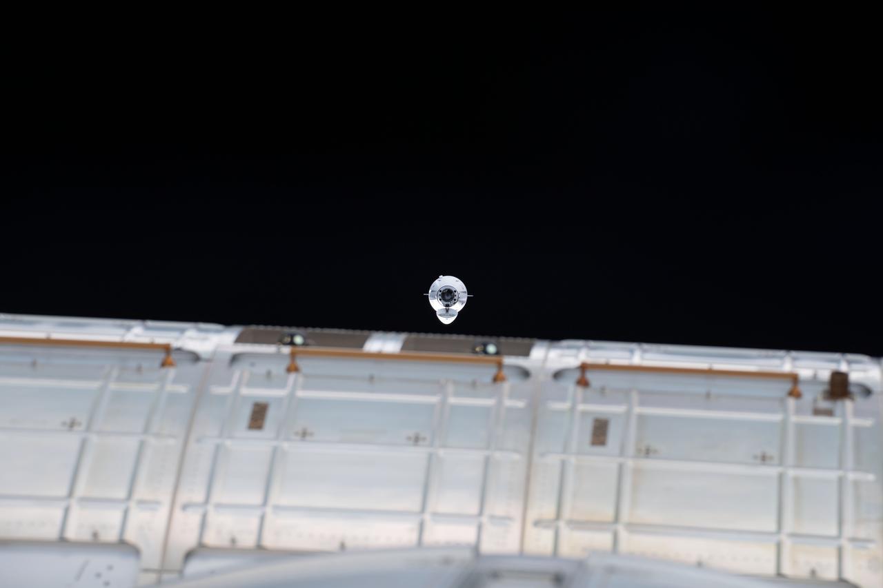 iss065e086862 (June 5, 2021) --- The SpaceX Cargo Dragon resupply ship is pictured approaching the International Space Station carrying over 7,300 pounds of new science, supplies and solar arrays to replenish the Expedition 65 crew. The Cargo Dragon's nose cone is open revealing its hatch and forward docking cone.