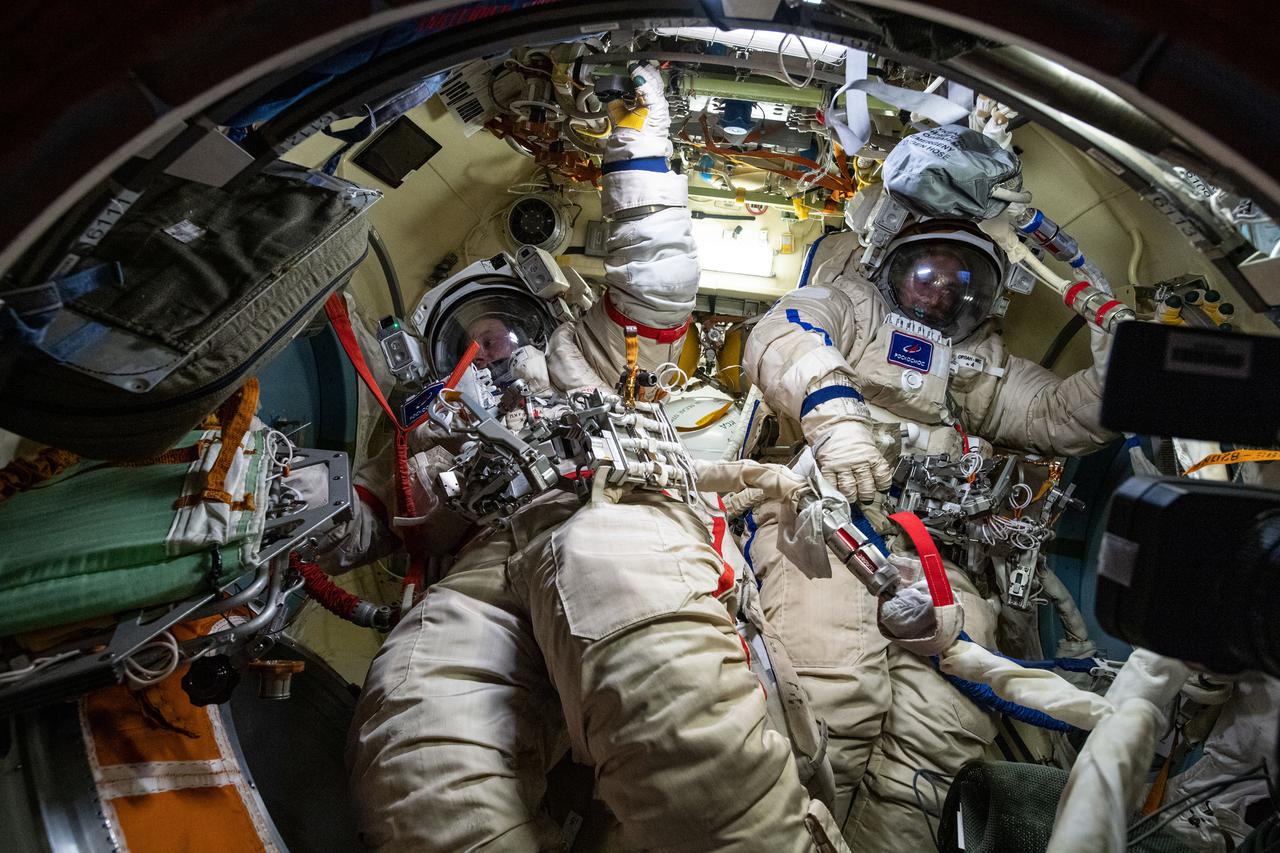 iss065e093418 (May 28, 2021) --- Roscosmos cosmonauts Oleg Novitskiy (left) and Pyotr Dubrov are pictured in their Russian Orlan spacesuits for tests a few days ahead of a spacewalk they conducted on June 2, 2021.