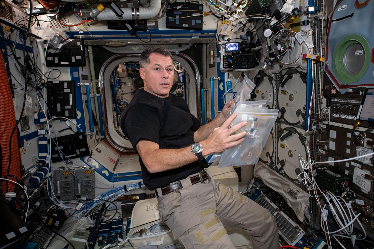 iss065e093509 (June 7, 2021) --- NASA astronaut and Expedition 65 Flight Engineer Shane Kimbrough checks out sample packs for the Oral Biofilms in Space study. The experiment observes how bacteria is affected by microgravity and investigates ways to counteract any potential harmful changes. Results could also have a positive influence for oral health on and off the Earth.