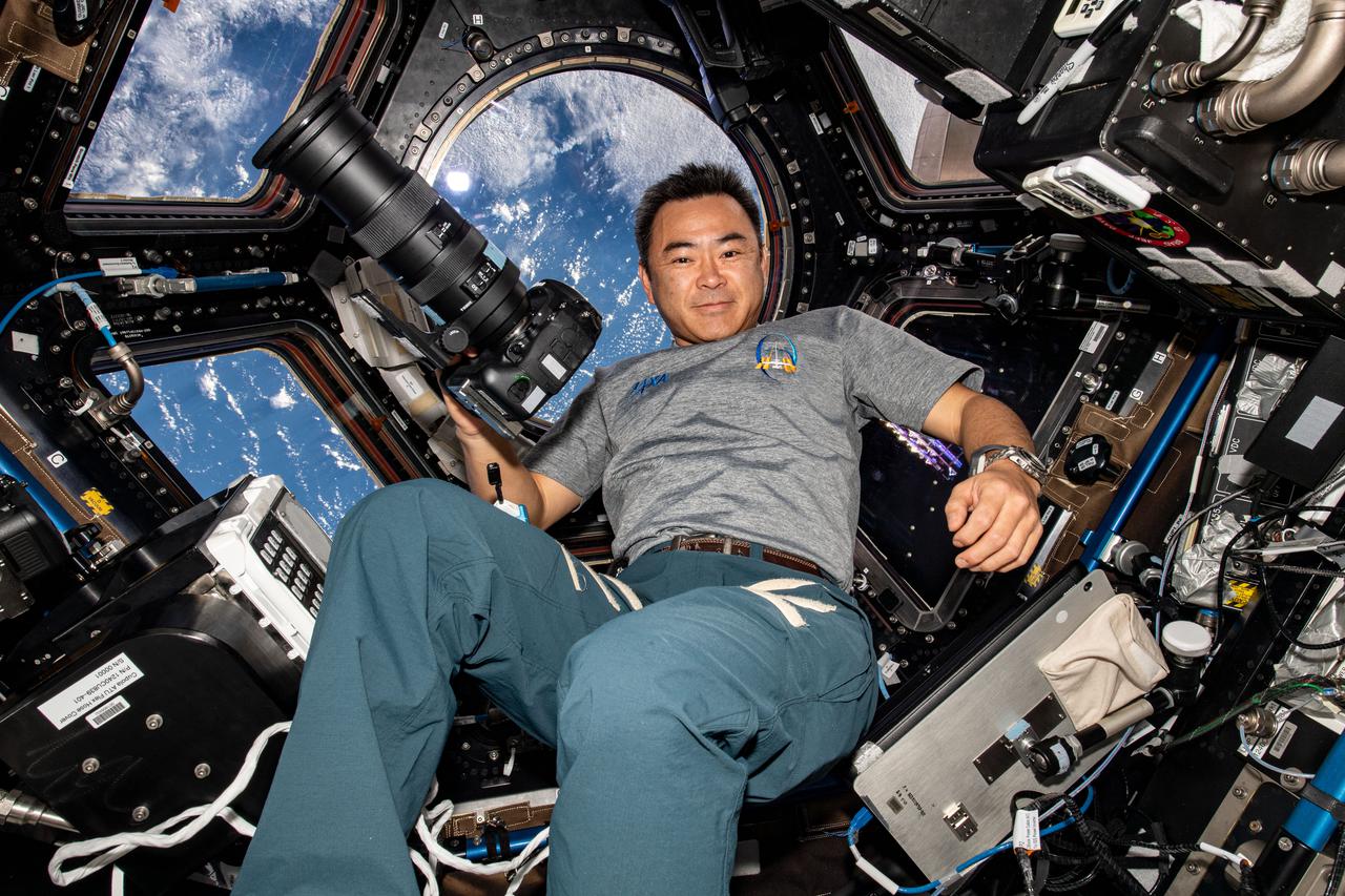 iss065e110749 (June 14, 2021) --- Expedition 65 Commander Akihiko Hoshide of the Japan Aerospace Exploration Agency (JAXA) is pictured inside the cupola, the International Space Station's "window to the world," during Earth photography activities.