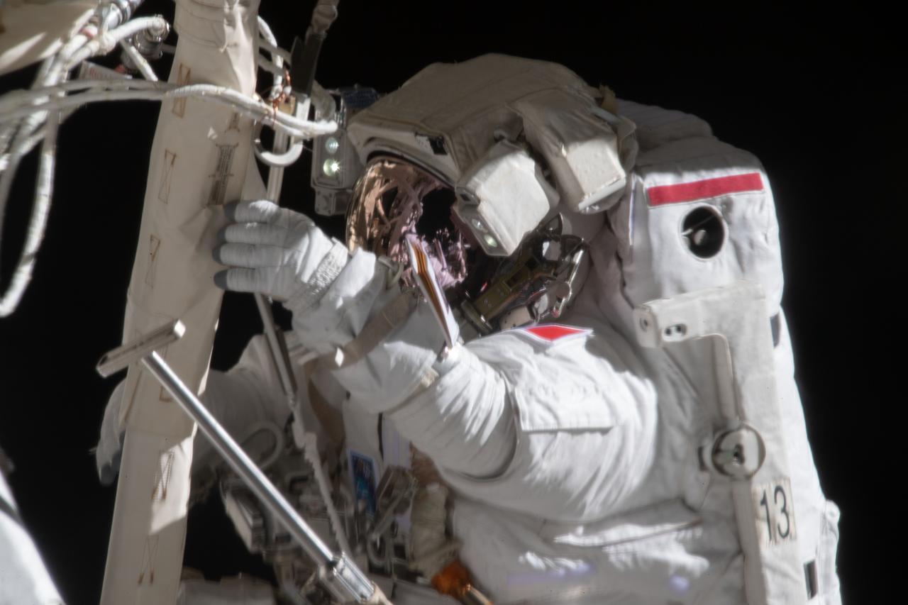 iss065e124498 (June 20, 2021) --- Spacewalker Thomas Pesquet of ESA (European Space Agency) works to complete the installation of a roll out solar array on the International Space Station's P-6 truss structure.