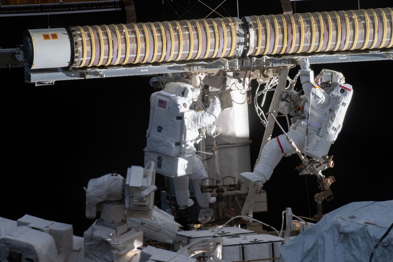 iss065e130510 (June 16, 2021) --- Spacewalkers (from left) Shane Kimbrough and Thomas Pesquet work to install new roll out solar arrays on the International Space Station's P-6 truss structure.