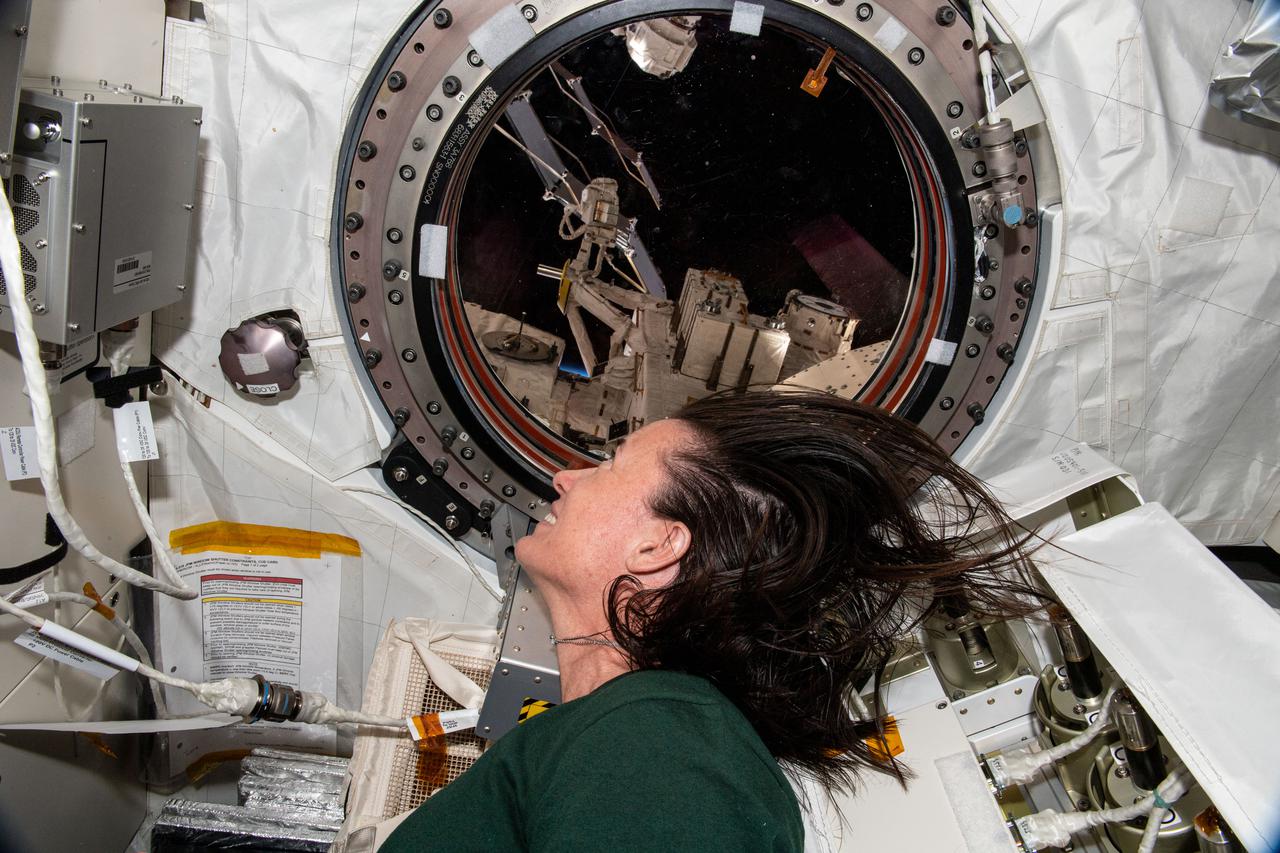 iss065e144303 (June 15, 2021) --- NASA astronaut and Expedition 65 Flight Engineer Megan McArthur looks out a window on the Kibo laboratory module at the Earth below and the Exposed Facility where microgravity experiments are placed to understand how the harsh environment of outer space affects a variety of materials.