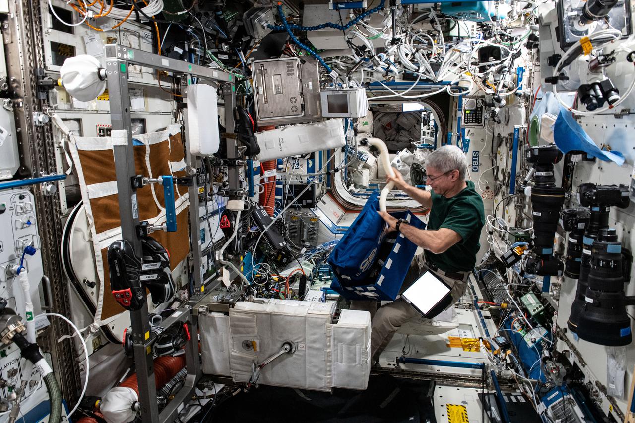 iss065e144326 (June 22, 2021) --- NASA astronaut and Expedition 65 Flight Engineer Mark Vande Hei sets up the International Space Station's exercise bicycle, also known as the Cycle Ergometer with Vibration Isolation and Stabilization (CEVIS), inside the U.S. Destiny laboratory module. Vande Hei later strapped himself on the CEVIS and attached sensors to himself for a workout study measuring aerobic capacity in space.