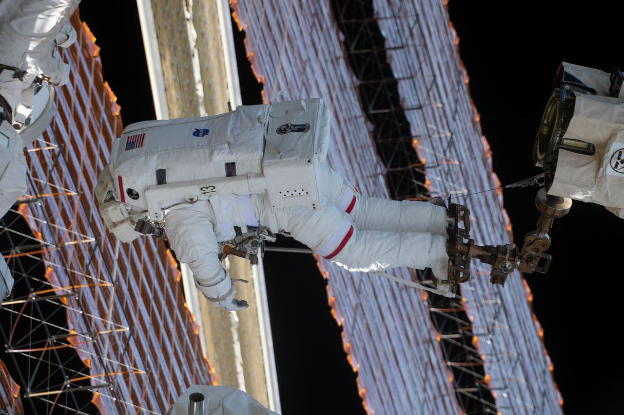 iss065e146916 (June 25, 2021) --- Spacewalker Thomas Pesquet of ESA (European Space Agency) is attached to the tip of the Canadarm2 robotic arm working to complete the installation of the second roll out solar array on the International Space Station's Port-6 truss structure.