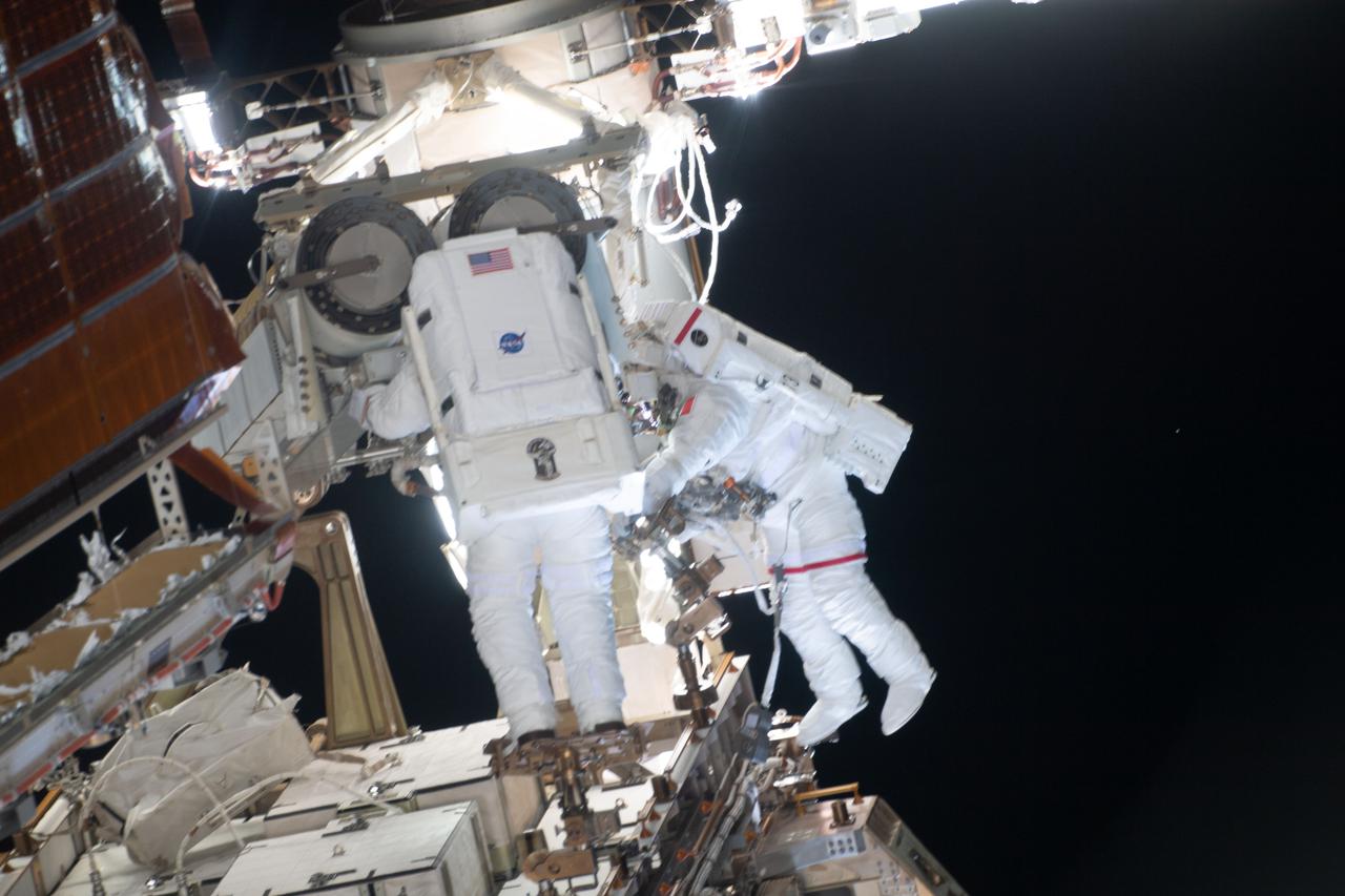 iss065e147262 (June 25, 2021) --- Spacewalkers (from left) Shane Kimbrough and Thomas Pesquet work to complete the installation of the second roll out solar array on the International Space Station's Port-6 truss structure.