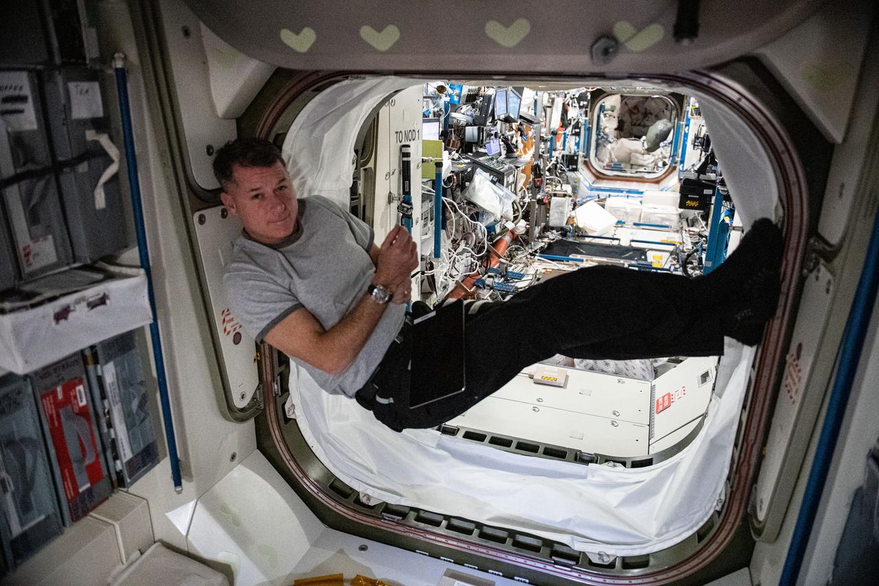 iss065e148861 (June 28, 2021) --- NASA astronaut and Expedition 65 Flight Engineer Shane Kimbrough rests inside the vestibule in between the Unity module and the U.S. Destiny laboratory module.