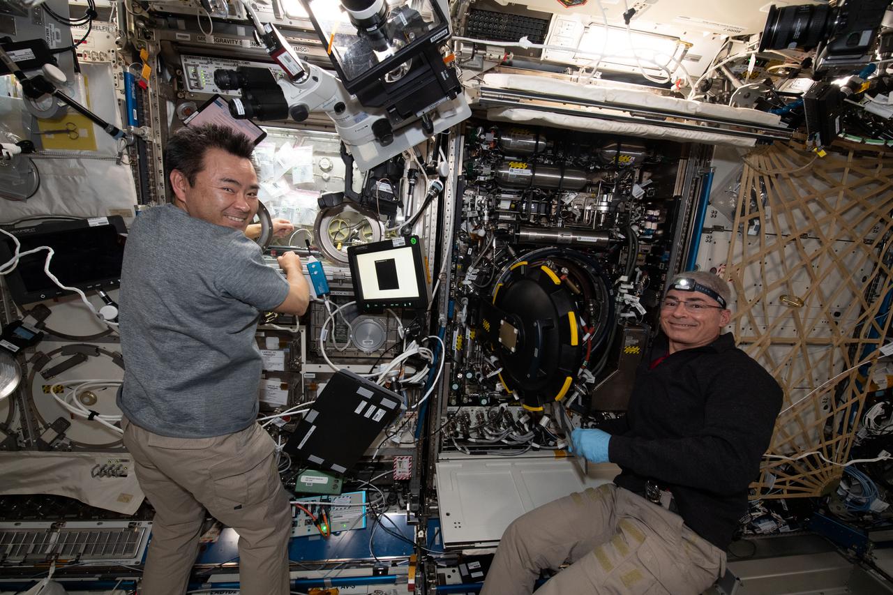 iss065e156007 (July 2, 2021) --- Expedition 65 astronauts Commander Akihiko Hoshide (left) and Flight Engineer Mark Vande Hei replace components inside the Combustion Integrated Rack that enables safe research into microgravity's effects on flames, fuel and soot aboard the International Space Station's U.S. Destiny laboratory module.
