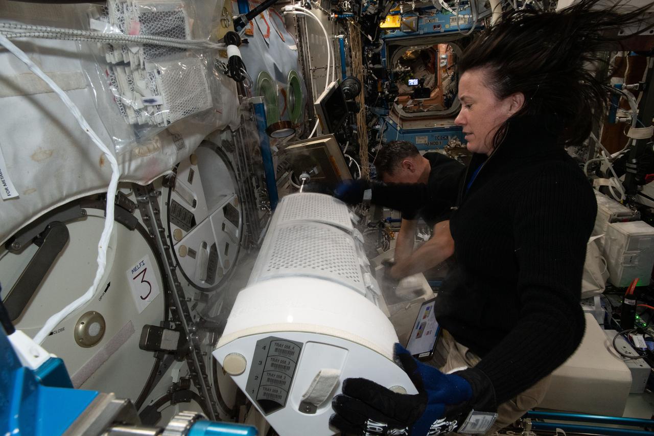 iss065e158844 (July 8, 2021) --- NASA astronaut and Expedition 65 Flight Engineer Megan McArthur prepares frozen research samples for transfer and stowage inside the SpaceX Cargo Dragon resupply ship ahead of the U.S. cargo craft's undocking and splashdown in the Gulf of Mexico.