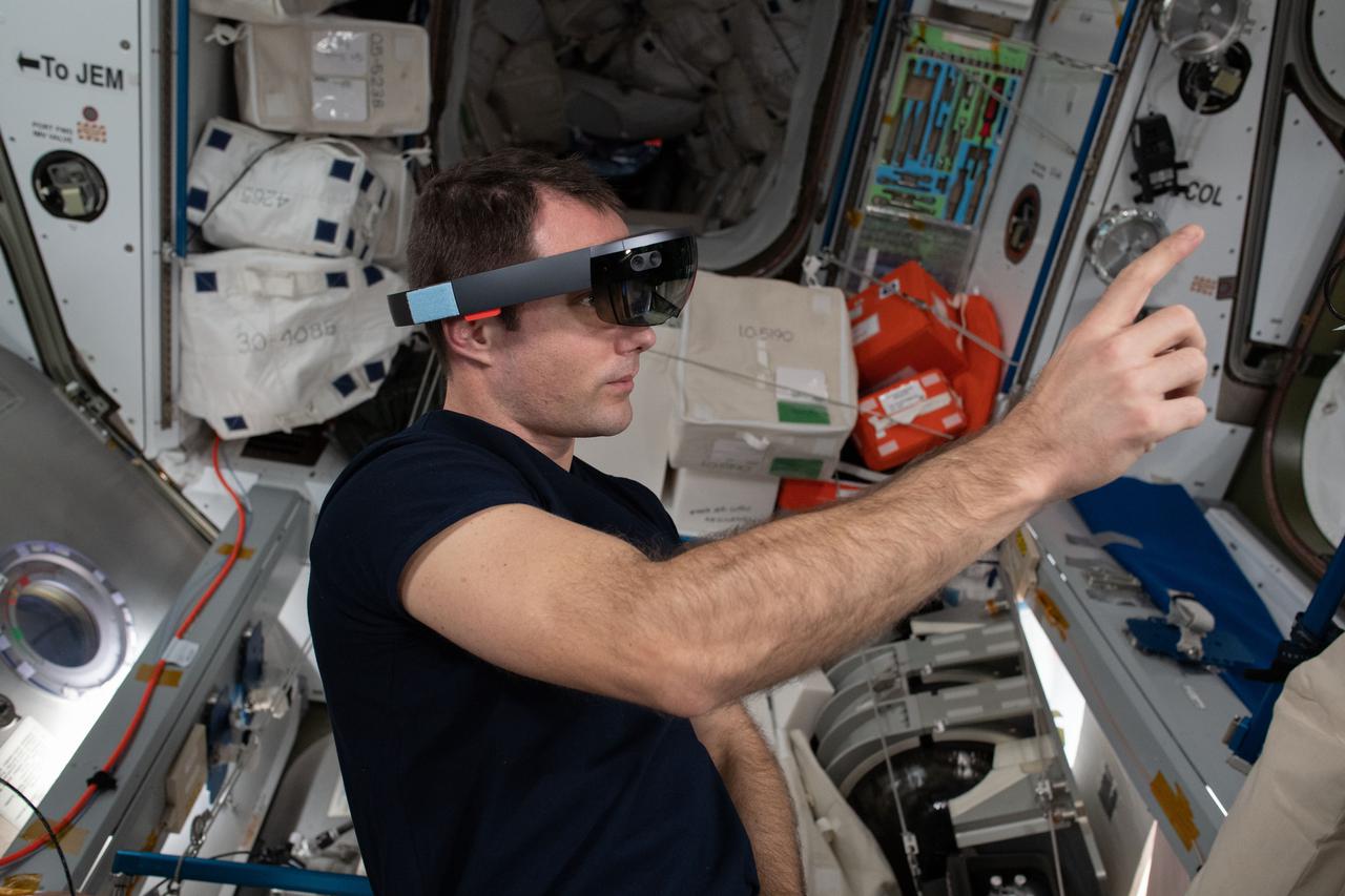 iss065e167797 (July 16, 2021) --- Expedition 65 Flight Engineer Thomas Pesquet of ESA (European Space Agency) wears Sidekick goggles to demonstrate using augmented reality while interacting with components aboard the International Space Station.