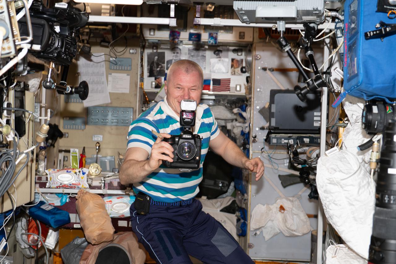 iss065e208553 (July 28, 2021) --- Roscosmos cosmonaut and Expedition 65 Flight Engineer Oleg Novitskiy is pictured during photography activities inside the International Space Station's Zvezda service module.