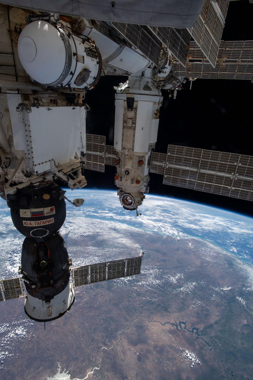 iss065e212156 (July 29, 2021) --- Russia's "Nauka" Multipurpose Laboratory Module is pictured shortly after docking to the Zvezda service module's Earth-facing port on the International Space Station with the Brazilian coast 263 miles below. In the foreground, is the Soyuz MS-18 crew ship docked to the Rassvet module.