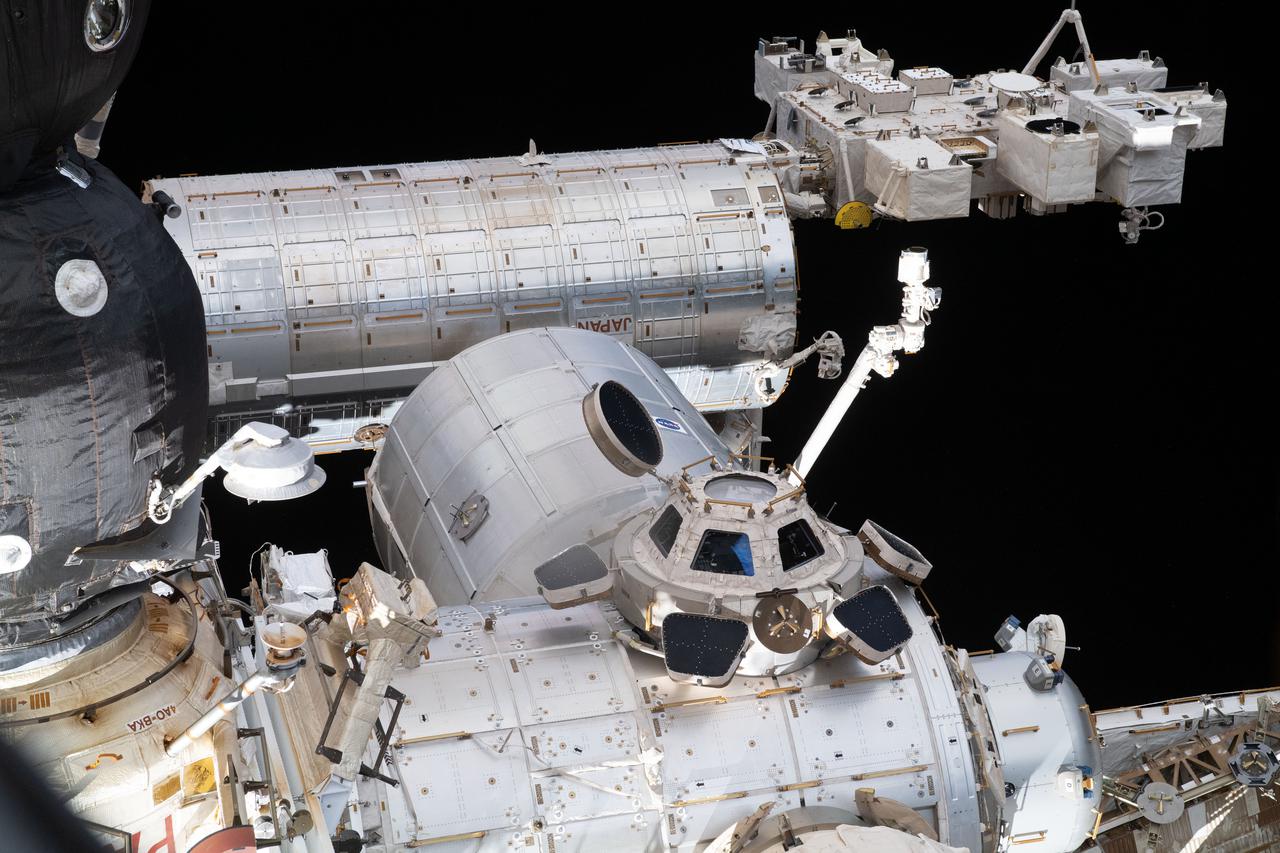 iss065e241371 (Aug. 12, 2021) --- Key portions of the International Space Station are pictured from a window on Russia's newest addition to the orbiting lab, the Nauka Multipurpose Laboratory Module. At left is part of the Soyuz MS-18 crew ship docked to the Rassvet module. From top to bottom are Japan's Kibo laboratory module with its attached Exposed Facility where a variety of experiments are placed in the vacuum of space, including: the Japanese robotic arm attached to Kibo; the Leonardo Multipurpose Logistics Module attached to the Tranquility module; and the seven-windowed cupola attached to Tranquility.