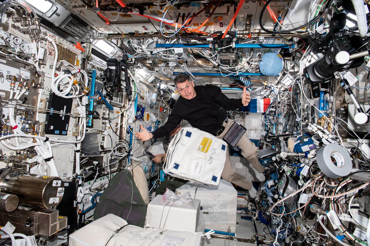 iss065e248590 (Aug. 16, 2021) --- NASA astronaut and Expedition 65 Flight Engineer Shane Kimbrough unpacks cargo bags inside the International Space Station's Columbus laboratory module.