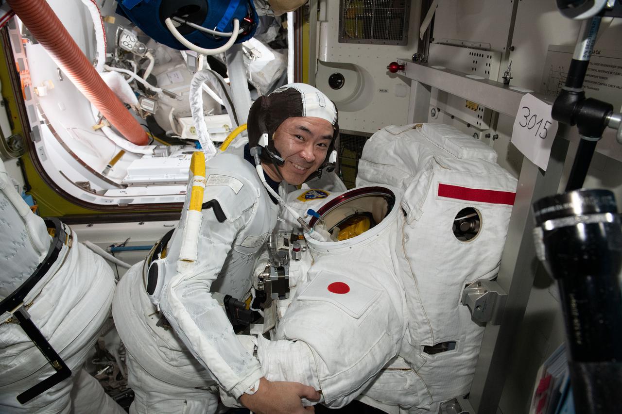 iss065e257472 (Aug. 17, 2021) --- Expedition 65 Commander Akihiko Hoshide of the Japan Aerospace Exploration Agency (JAXA) participates in a U.S. spacesuit fit check to get ready for a spacewalk preparing the International Space Station for the future installation of a third Roll-Out Solar Array.