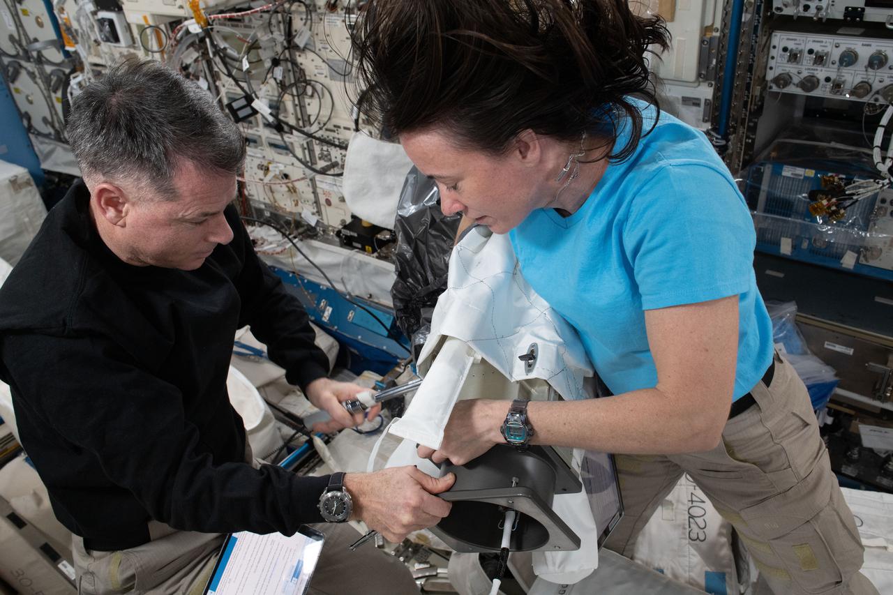 iss065e257482 (Aug. 16, 2021) --- NASA astronauts and Expedition 65 Flight Engineers Shane Kimbrough and Megan McArthur work on a Floating Potential Measurement Unit (FPMU) that will be installed on the outside of the International Space Station on an upcoming spacewalk. The FPMU is a device that measures electrical charges that can build on solar arrays and surfaces on spacecraft for astronaut safety and to promote safe deep space exploration.