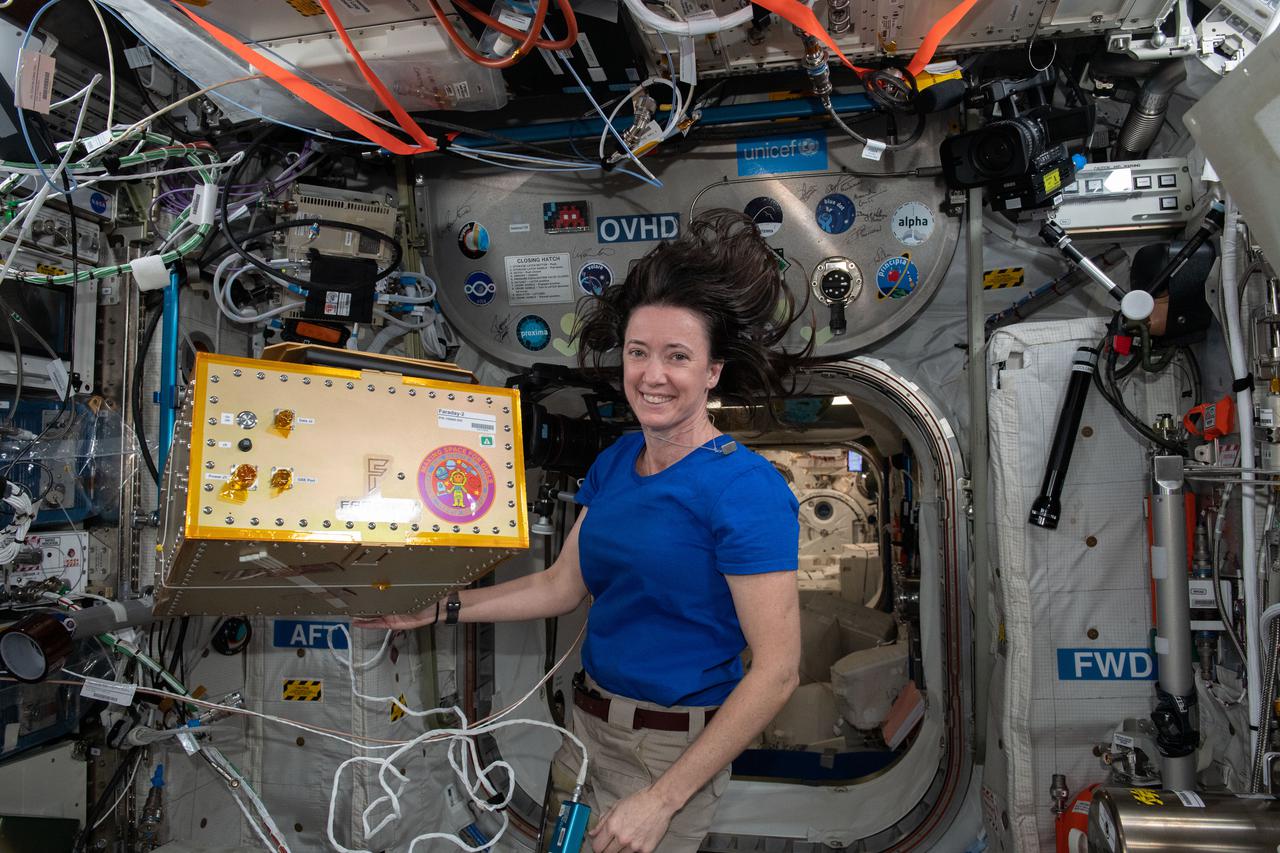 iss065e335890 (Aug. 31, 2021) --- NASA astronaut and Expedition 65 Flight Engineer Megan McArthur installs the Faraday-2 facility inside the International Space Station's U.S. Destiny laboratory module. The payload gives the Girl Scouts on Earth the opportunity to conduct a control experiment while observing space station experiments on plant growth, ant colonization, and brine shrimp lifecycle aboard the orbiting lab.