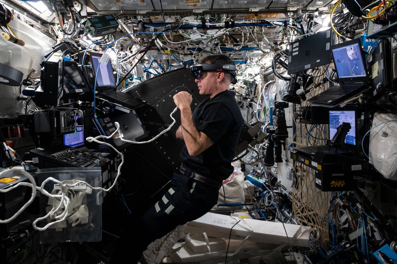 iss065e358558 (Sept. 7, 2021) --- NASA astronaut and Expedition 65 Flight Engineer Shane Kimbrough wears an augmented reality headset while servicing hardware on the International Space Station.