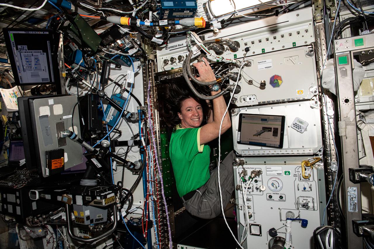 iss065e369753 (Sept. 9, 2021) --- NASA astronaut and Expedition 65 Flight Engineer Megan McArthur configures an EXPRESS rack inside the U.S. Destiny laboratory module before installing a new device that scrubs the International Space Station's atmosphere of carbon dioxide.