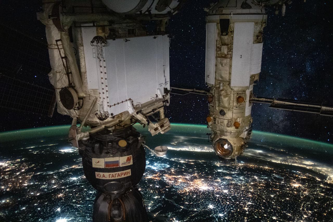 iss065e370839 (Sept. 10, 2021) --- From front to back, Russia's Soyuz MS-18 spacecraft docked to the Rassvet module and the Nauka multipurpose laboratory module attached to the Zvezda module. The International Space Station was orbiting 264 miles above eastern Europe in this night time photograph that also highlights the Earth's airglow and the Milky Way.