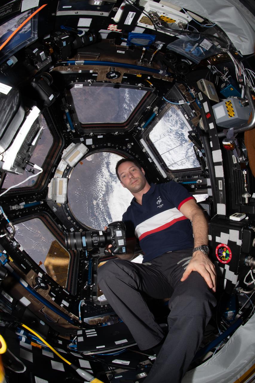 iss065e389253 (Sept. 19, 2021) --- Expedition 65 Flight Engineer Thomas Pesquet of ESA (European Space Agency) is pictured during Earth photography activities inside the seven-windowed cupola, the International Space Station's "window to the world."