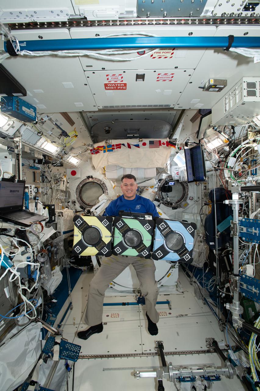 iss065e389375 (9/20/2021) --- NASA astronaut Shane Kimbrough poses with the Astrobee robotic free-flyers in support of the Kibo Robot Programming Challenge (Robo-Pro Challenge). The Kibo-RPC, allows students to create programs to control Astrobee, a free-flying robot aboard the International Space Station (ISS).