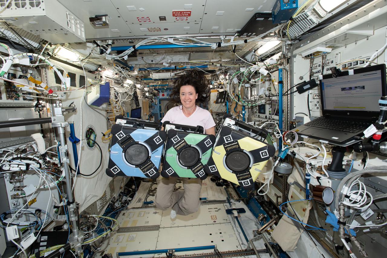 iss065e389383 (9/20/2021) --- NASA astronaut Megan McArthur poses with the Astrobee robotic free-flyers in support of the Kibo Robot Programming Challenge (Robo-Pro Challenge). The Kibo-RPC, allows students to create programs to control Astrobee, a free-flying robot aboard the International Space Station (ISS).