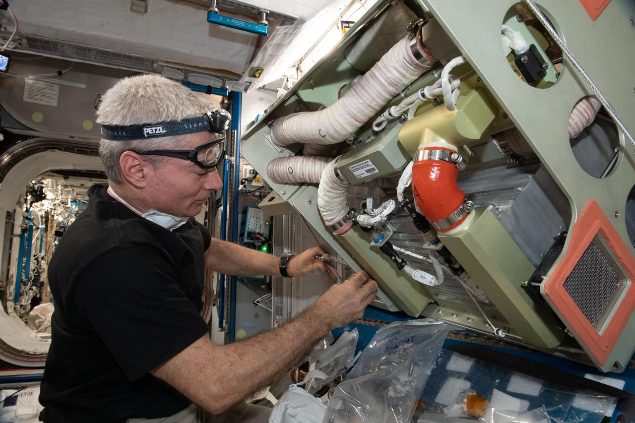 iss065e389623 (Sept. 20, 2021) --- NASA astronaut and Expedition 65 Flight Engineer Mark Vande Hei replaces components inside a life support device that removes carbon dioxide from the International Space Station's atmosphere.