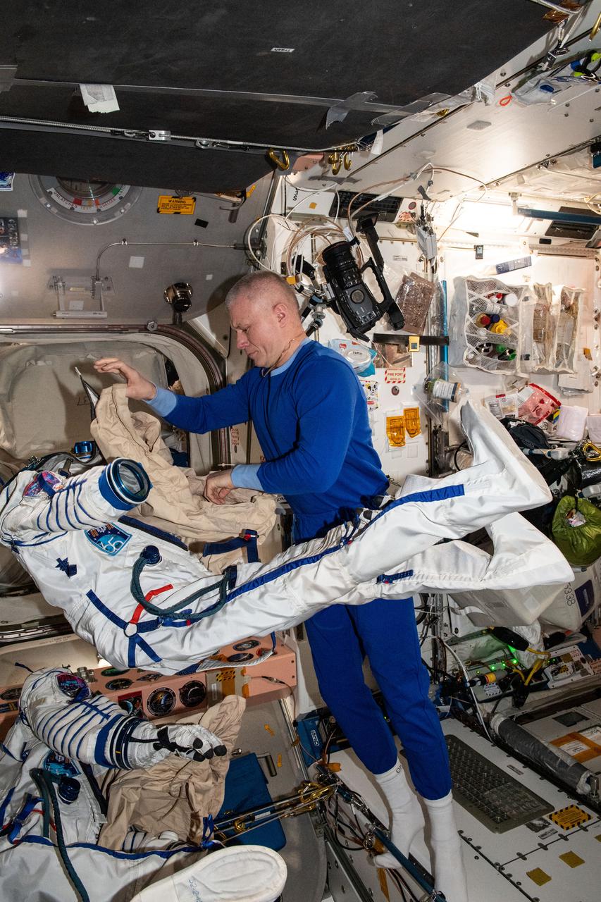 iss065e398664 (Sept. 21, 2021) --- Roscosmos cosmonaut and Expedition 65 Flight Engineer Oleg Novitskiy tries on the Sokol launch and entry suit he will wear inside the Soyuz MS-18 crew ship when it undocks from the Rassvet module and redocks to the Nauka multipurpose module.