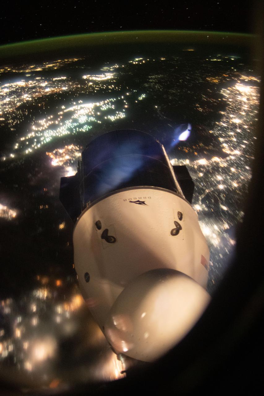 iss065e434288 (Sept. 30, 2021) --- The SpaceX Cargo Dragon resupply ship is pictured from a window on the SpaceX Crew Dragon vehicle. The International Space Station was orbiting 263 miles above Beijing, China, and about to cross over the Yellow Sea at the time this photograph was taken.