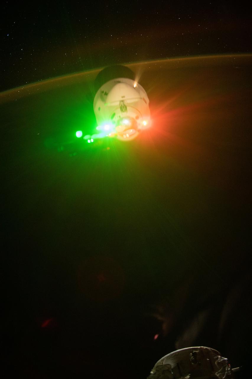 iss065e434505 (Sept. 30, 2021) --- The SpaceX Cargo Dragon resupply ship is pictured as it backs away from the International Space Station's forward-facing international docking adapter. The Cargo Dragon's beacon lights and a plume from one of its engines during its departure burn made for a colorful show.