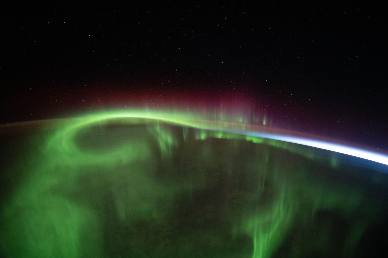 iss065e453585 (Oct. 10, 2021) --- A aurora vividly streams over the Earth as the International Space Station orbited 273 miles above the southern Indian Ocean in between Australia and Antarctica.