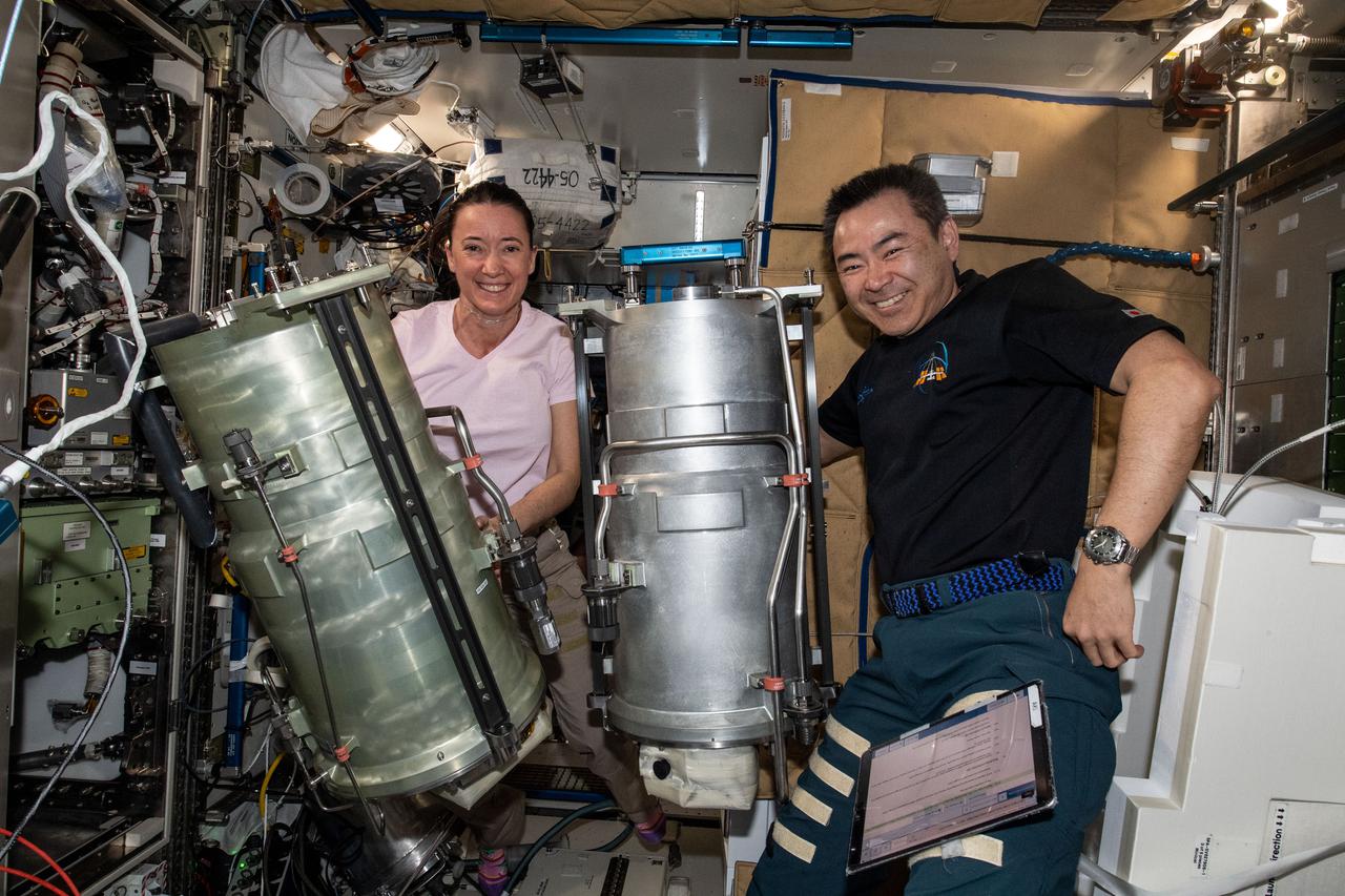 iss066e003308 (Oct. 20, 2021) --- Expedition 66 Flight Engineers Megan McArthur of NASA and Akihiko Hoshide of the Japan Aerospace Exploration Agency (JAXA) replace components and flush contaminants inside the Tranquility module's U.S. oxygen generation system.