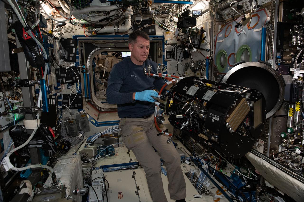 iss066e031702 (Nov. 2, 2021) --- NASA astronaut and Expedition 66 Flight Engineer Shane Kimbrough reconfigures and replaces hardware inside the U.S. Destiny laboratory module's Combustion Integrated Rack (CIR). The CIR is a research device that enables safe experiments with fuel, flames, and soot aboard the International Space Station.