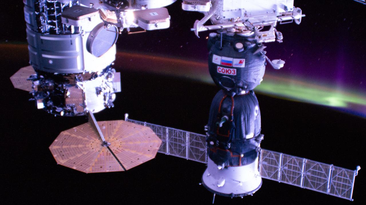 iss066e037536 (Nov. 4, 2021) --- Two spacecraft (from left), the U.S. Northrop Grumman Cygnus space freighter and Russia's Soyuz MS-19 crew ship, are pictured attached to the International Space Station as it orbited 267 miles above eastern Australia with an aurora on the horizon.