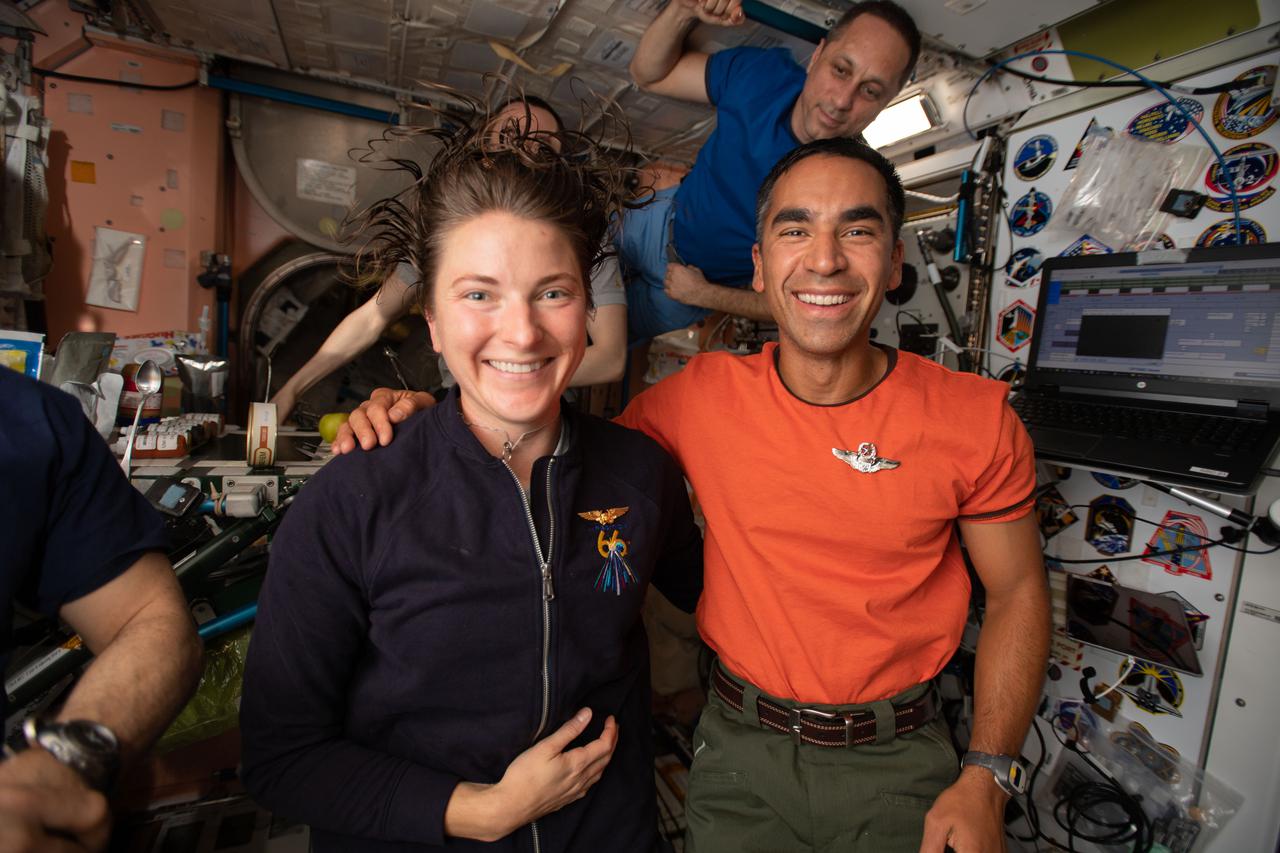 iss066e081649 (Nov. 21, 2021) --- NASA astronauts and Expedition 66 Flight Engineers Kayla Barron and Raja Chari pose for a portrait with Roscosmos cosmonaut and International Space Station Commander Anton Shkaplerov (background).