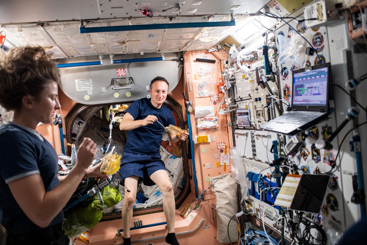 iss066e081876 (Nov. 24, 2021) --- Expedition 66 Flight Engineers Kayla Barron of NASA and Matthias Maurer of ESA (European Space Agency) have lunch together inside the International Space Station's Unity module.