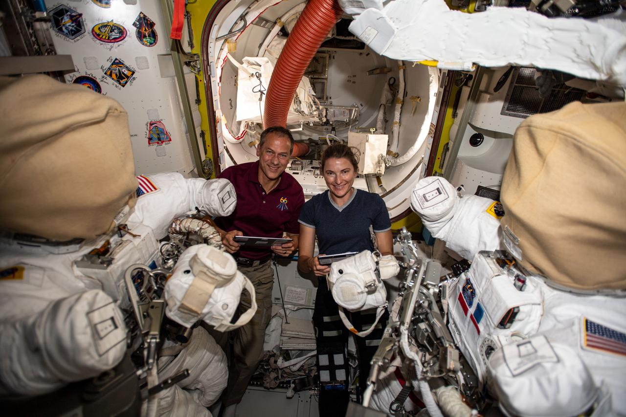 iss066e082988 (Nov. 24, 2021) --- NASA astronauts and Expedition 66 Flight Engineers Thomas Marshburn and Kayla Barron work on U.S. spacesuits inside the International Space Station's Quest airlock.