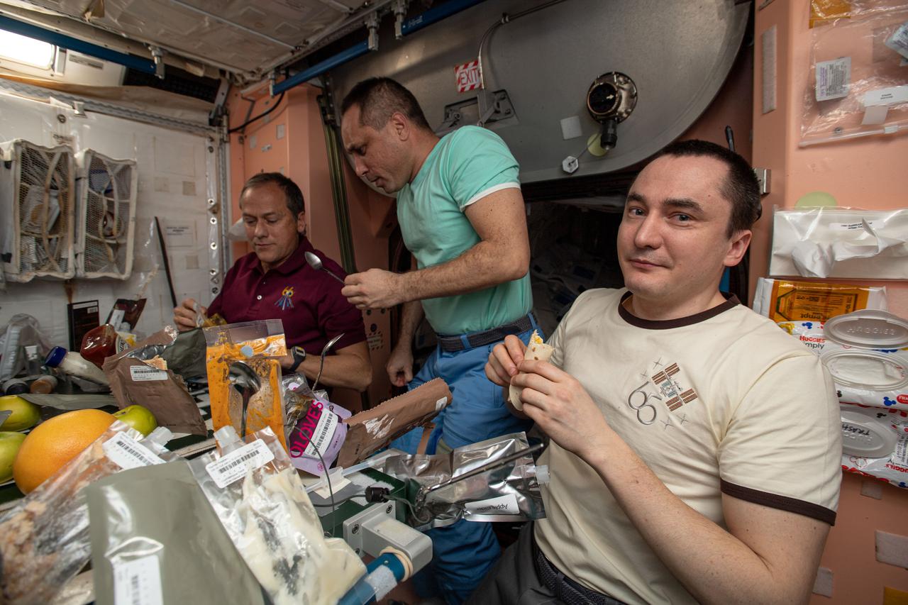 iss066e083008 (Nov. 25, 2021) --- Expedition 66 crew members gather for a Thanksgiving meal inside the International Space Station's Unity module. From left, are NASA astronaut Thomas Marshburn with Roscosmos cosmonauts Anton Shkaplerov and Pyotr Dubrov.