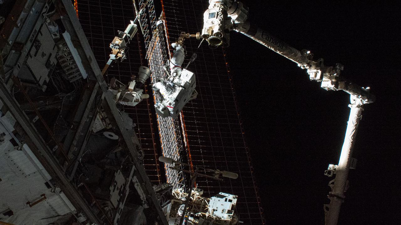iss066e085095 (Dec. 2, 2021) --- NASA spacewalker Thomas Marshburn is pictured attached to the tip of the Canadarm2 robotic arm during a six-hour and 32 minute spacewalk to replace a failed antenna system on the International Space Station's Port-1 truss structure.